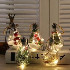 three glass vases with christmas lights in them