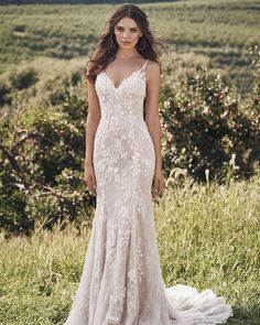 a woman in a wedding dress standing on the grass