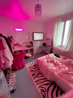 a bedroom with pink lighting and zebra print rug