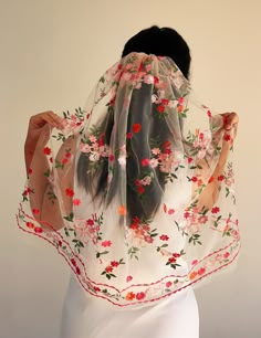 a woman wearing a veil with flowers on it