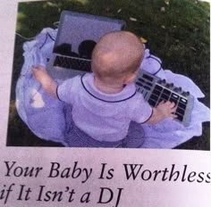 a baby is sitting on the ground with a keyboard in it's lap and has an ad for its website