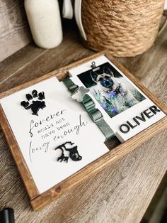 a wooden tray with pictures and writing on it sitting on a table next to some baskets