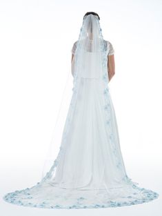 the back of a bride's wedding dress, with blue flowers on her veil