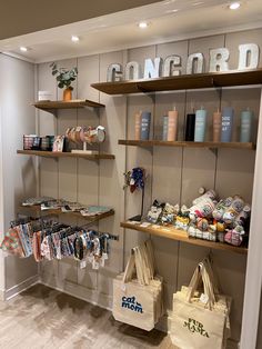 there are many items on the shelves in this store, including tote bags and t - shirts