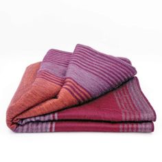 three towels folded on top of each other in different colors and patterns, with one folded up