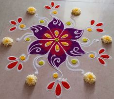 a colorful flower design on the ground with pom poms