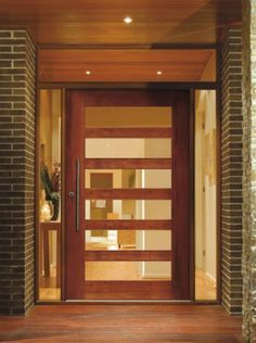 a wooden door with glass and brick pillars