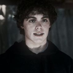 a young man with curly hair wearing a black shirt