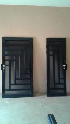 two black doors are open in an empty room