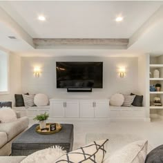 a living room filled with furniture and a flat screen tv mounted to the wall above it