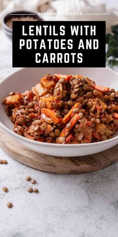 lentils with potatoes and carrots in a white bowl on top of a wooden board