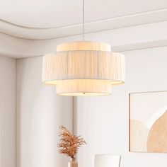 a living room with white furniture and a chandelier hanging from the ceiling above it