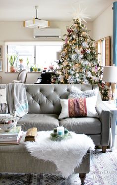 a living room filled with furniture and a christmas tree