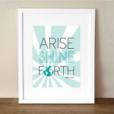 an art print with the words rise shine forth in blue and green on a wooden shelf