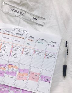 a planner and pen sitting on top of a bed