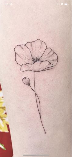 a single flower is shown on the side of a woman's leg, which has been