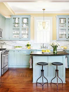 a kitchen with blue cabinets and wooden floors