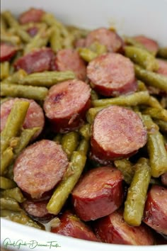 a white bowl filled with green beans and sausage