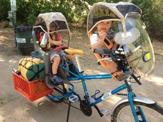 two children are riding on a bike with baskets