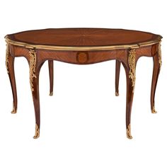 an oval shaped table with gold trimmings on the top and legs, inlaid to