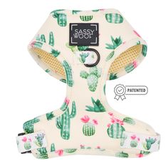 a white dog harness with cactus print on the front and back, has a black tag that reads sasy wool