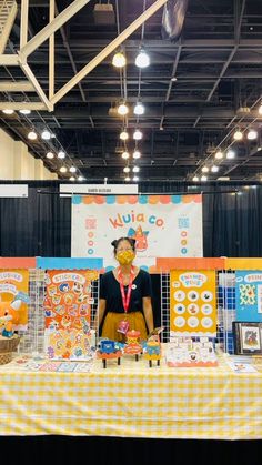 a woman standing in front of a table with food on it and decorations around her