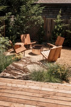 an outdoor fire pit surrounded by wooden chairs