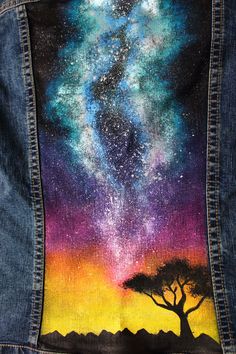 a painted jean jacket with an image of a tree and the stars in the sky