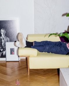 a man sitting on a couch with his legs crossed and feet propped up in the air