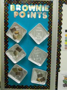 some brownie points are placed in plastic containers on a bulletin board with polka dots