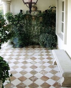 an entry way with potted plants and a lamp hanging from the ceiling above it