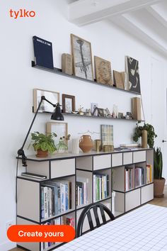 a dining room table with chairs and bookshelves on the wall next to it