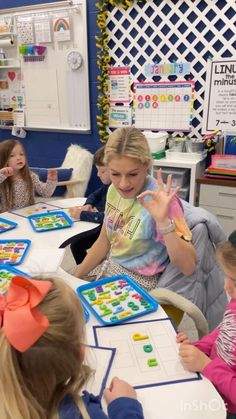 a group of children sitting around a table playing with magnets on the board game