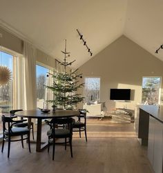 a living room filled with furniture and a christmas tree in the middle of the room