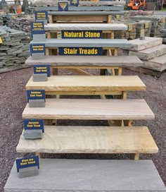 several wooden benches sitting on top of a pile of rocks next to piles of stones