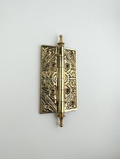 an ornate brass door handle on a white wall