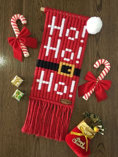 a knitted christmas stocking with candy canes and other holiday decorations around it