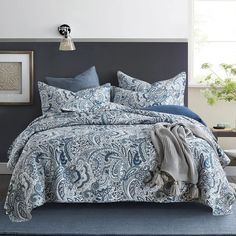 a bed with blue and white comforters in a room