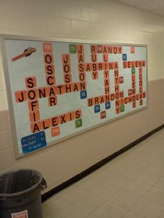 a bulletin board with words written on it in a hallway next to a trash can