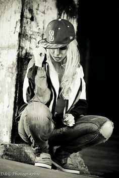 black and white photograph of a woman sitting on a skateboard