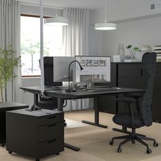 an office with two desks and a chair in front of the computer monitor on the desk