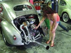 a woman working on a car in a garage