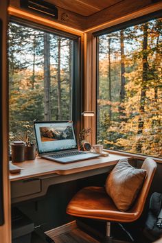 an open laptop computer sitting on top of a wooden desk next to a large window