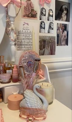 there is a swan statue on the desk next to candles and other things in front of it