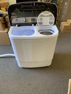 a white washing machine sitting on top of a carpeted floor