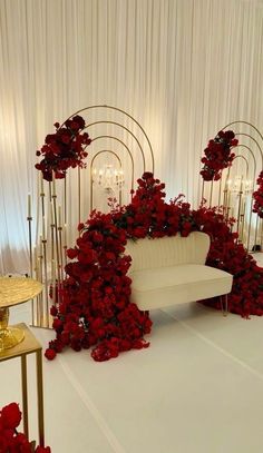 a white couch surrounded by red flowers and candles