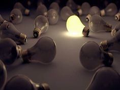 a group of light bulbs sitting in the middle of a room filled with one glowing bulb