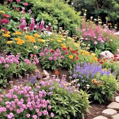 many different colored flowers growing on the side of a hill