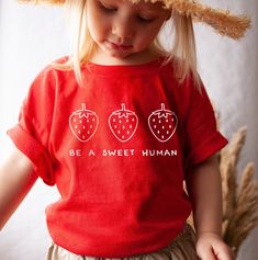 Your toddler will look adorable in this cute tshirt that features strawberries and the words Be a Sweet Human. This super soft tee is perfect for infants and toddlers sensitive skin. Make a great gift for a strawberry lover. * Q U I C K * F A C T S * ♥ 100% cotton ♥ Design is high quality digital print ♥ Wash and dry normally (on cool for best results) * S I Z I N G * ♥ 2T: 30-33 lb / 32-35'' ♥ 3T: 33-36 lb / 35-38'' ♥ 4T: 36-40 lb / 38-40'' ♥ 5T: 40-45 lb / 40-43'' ♥ Please see size guide in li Red Crew Neck T-shirt, Sweet Red Crew Neck Top, Sweet Red Summer Tops, Fun Strawberry Print Crew Neck T-shirt, Cute Unisex Slogan Tops, Red Sweet Crew Neck T-shirt, Sweet Cotton Tops With Fruit Print, Sweet Style Red Crew Neck T-shirt, Cute Strawberry Print T-shirt For Spring