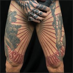 a man with tattoos on his legs and arms is holding his hands behind his back